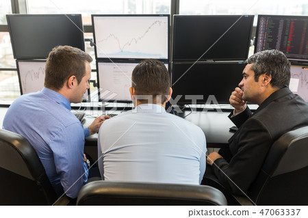 Business team brainstorming while checking data at computer screens. 47063337