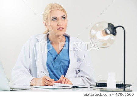 Doctor in hospital working on medical report. Doctor in hospital working on medical report. 47065560