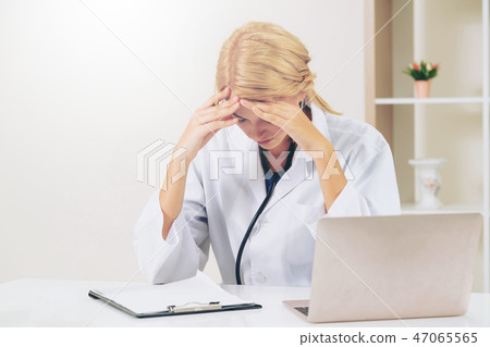 Serious doctor working in hospital office. Serious doctor working in hospital office. 47065565