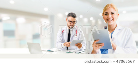 Doctor at hospital works on computer with partner. 47065567