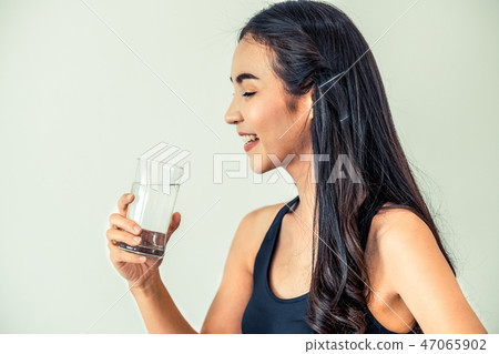 Woman in sportswear drinking water in fitness gym. Woman in sportswear drinking water in fitness gym. 47065902