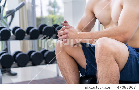 Muscular man bodybuilder training with dumbbells. Muscular man bodybuilder training with dumbbells. 47065908