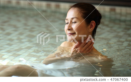 Woman bathing in a bath 47067400