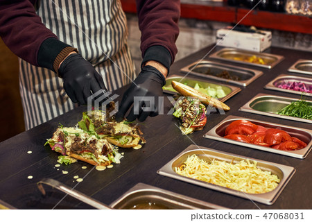 A chef preparing a sandwich with fresh salad. Food cort of street fair 47068031