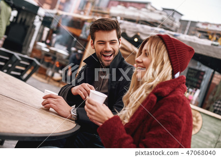Young couple are speaking while drinking hot beverage, tea or coffee. Young couple are speaking while drinking hot beverage, tea or coffee. 47068040