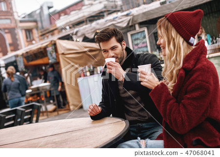Young couple are speaking while drinking hot beverage, tea or coffee. Young couple are speaking while drinking hot beverage, tea or coffee. 47068041