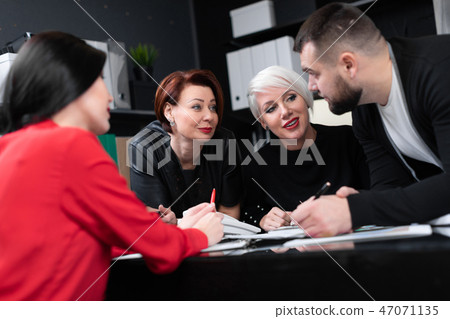 Smiling employees talking in workplace 47071135