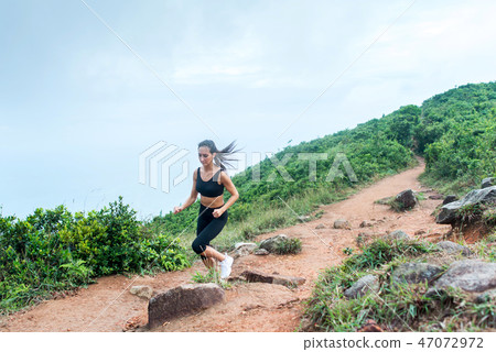 Sporty young woman in black sportswear trail running on mountain nature path. Fit girl jogging Sporty young woman in black sportswear trail running on mountain nature path. Fit girl jogging 47072972