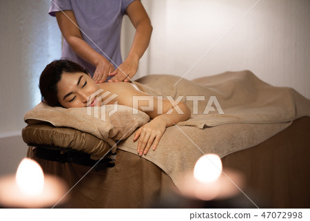 Masseuse doing massage Masseuse doing massage 47072998