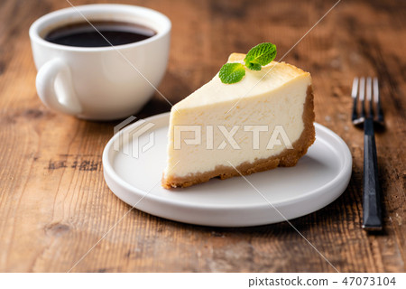 Cheesecake and cup of coffee on wooden table Cheesecake and cup of coffee on wooden table 47073104