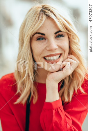 Smiling blonde girl with red shirt enjoying life outdoors. Smiling blonde girl with red shirt enjoying life outdoors. 47073207