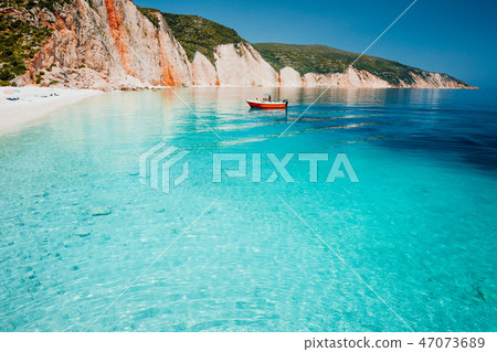 Tourist pleasure boat land to beautiful remote white pebble beach with transparent clear blue sea Tourist pleasure boat land to beautiful remote white pebble beach with transparent clear blue sea 47073689