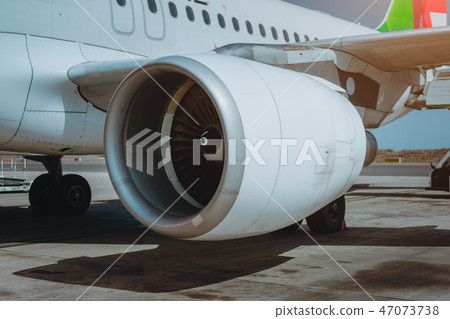 Turbine of passenger jet that waiting for departure in airport in warm afternoon light 47073738