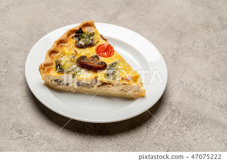 Slice of traditonal homemade spinach chicken quiche tart or pie on plate 47075222
