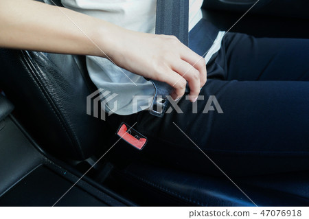 Woman hand fastens the seat belts Woman hand fastens the seat belts 47076918