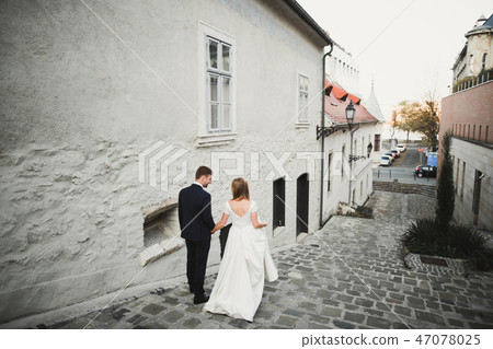 Gorgeous wedding couple walking in the old city Gorgeous wedding couple walking in the old city 47078025