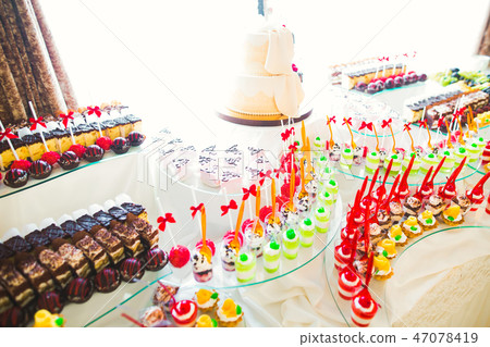 Delicious sweets on wedding candy buffet with desserts, cupcakes Delicious sweets on wedding candy buffet with desserts, cupcakes 47078419