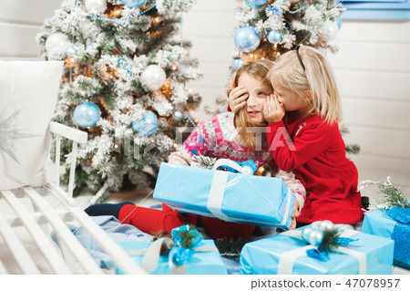 Happy little kids opening presents on Christmas eve Happy little kids opening presents on Christmas eve 47078957