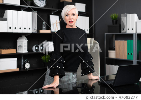 young girl stands near computer Desk in a stylish business office 47082277