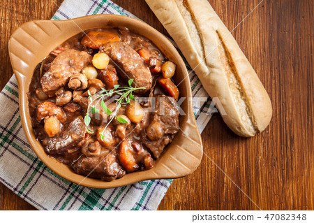 Beef Bourguignon stew served with baguette Beef Bourguignon stew served with baguette 47082348