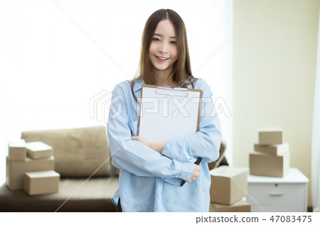 Young Asian business holding clipboard at home 47083475