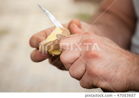 Potato peel, hands of cook with knife, close-up Potato peel, hands of cook with knife, close-up 47083687