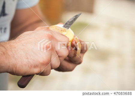 Raw potato peel, hands of cook with knife 47083688
