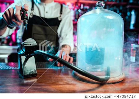 Expert barman is making cocktail at night club. Expert barman is making cocktail at night club. 47084717