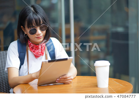 Happy traveler Asian woman hipster using tablet  47084777