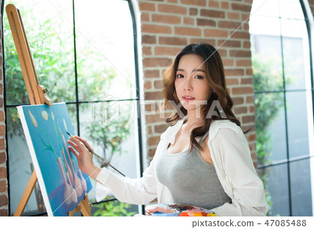 Beautiful young woman painting on a canvas finish 47085488