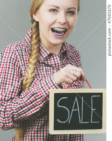 Woman holding sign banner with sale 47085878