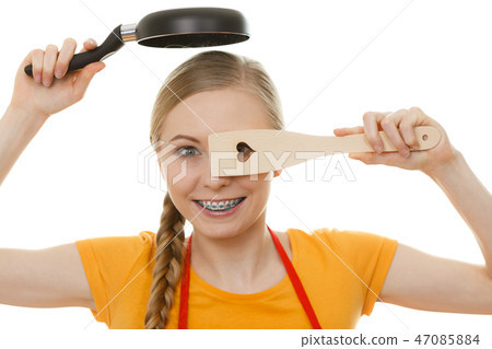 Woman holding cooking pan and spatula Woman holding cooking pan and spatula 47085884