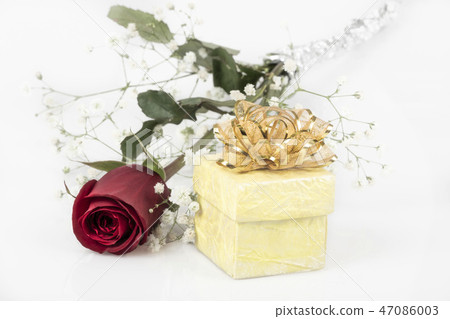 Red rose and yellow gift box on white 47086003