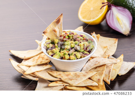 guacamole with corn chips closeup 47086233