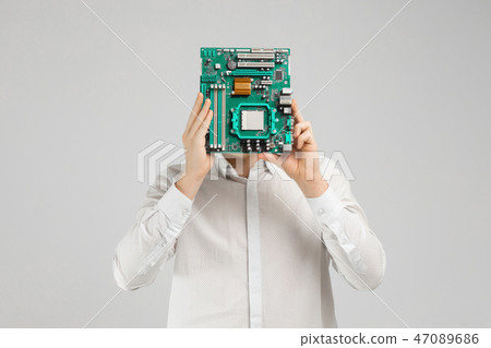young man hid his face behind motherboard isolated on light background young man hid his face behind motherboard isolated on light background 47089686