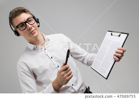 Young man in glasses and headphones with insurance in hands isolated on white background 47089755