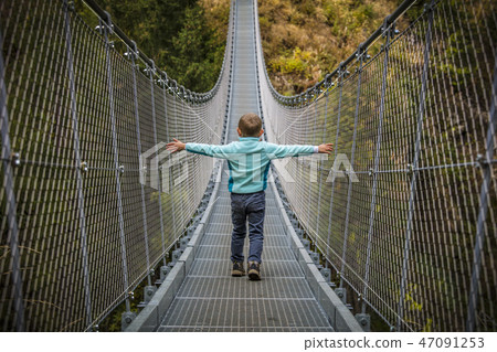 kid on suspended bridge kid on suspended bridge 47091253