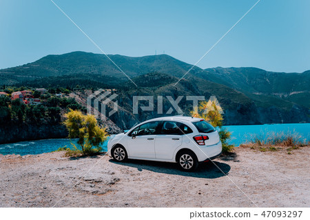 Vacation travel with car concept. Rental hired car in front of amazing bay with turquoise water 47093297