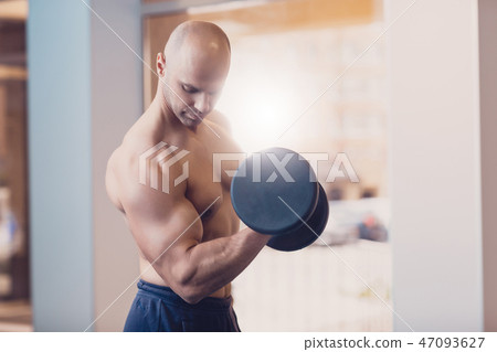 Pensive man doing strength exercise dumbbell hands Pensive man doing strength exercise dumbbell hands 47093627