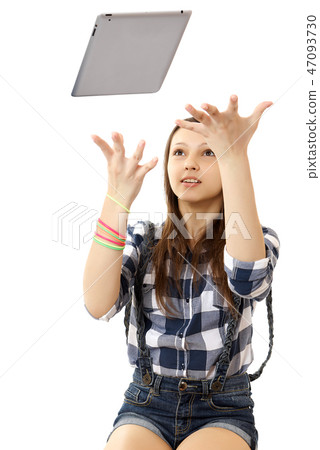 The girl throws in the air tablet PC . The girl throws in the air tablet PC . 47093730