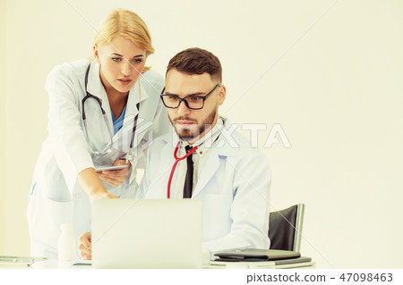 Doctor at hospital works on computer with partner. 47098463