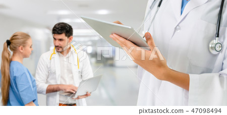 Doctor working in hospital with other doctors. Doctor working in hospital with other doctors. 47098494