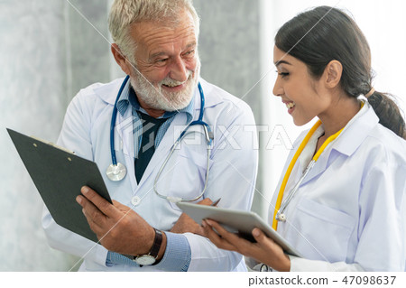Doctors working with tablet computer at hospital. Doctors working with tablet computer at hospital. 47098637