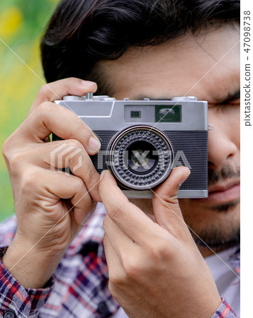 Young hipster man taking photo with retro camera. 47098738