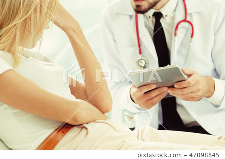 Male Doctor and Female Patient in Hospital Office Male Doctor and Female Patient in Hospital Office 47098845