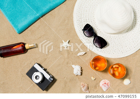 drinks, hat, camera and sunglasses on beach sand drinks, hat, camera and sunglasses on beach sand 47099155