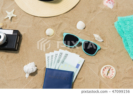 money in passport, shades and hat on beach sand money in passport, shades and hat on beach sand 47099156