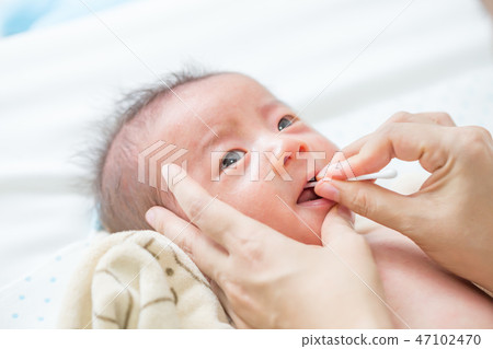 Asian newborn baby cleaning tongue, cheek bulge  47102470