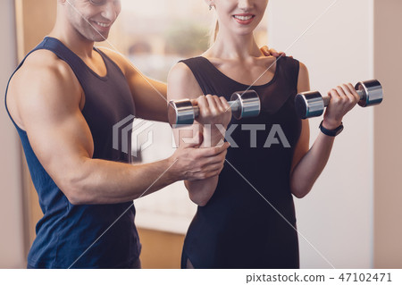 Happy girl doing strength exercise dumbbell hands Happy girl doing strength exercise dumbbell hands 47102471