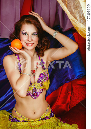 Oriental beauty is holding an orange Oriental beauty is holding an orange 47104499